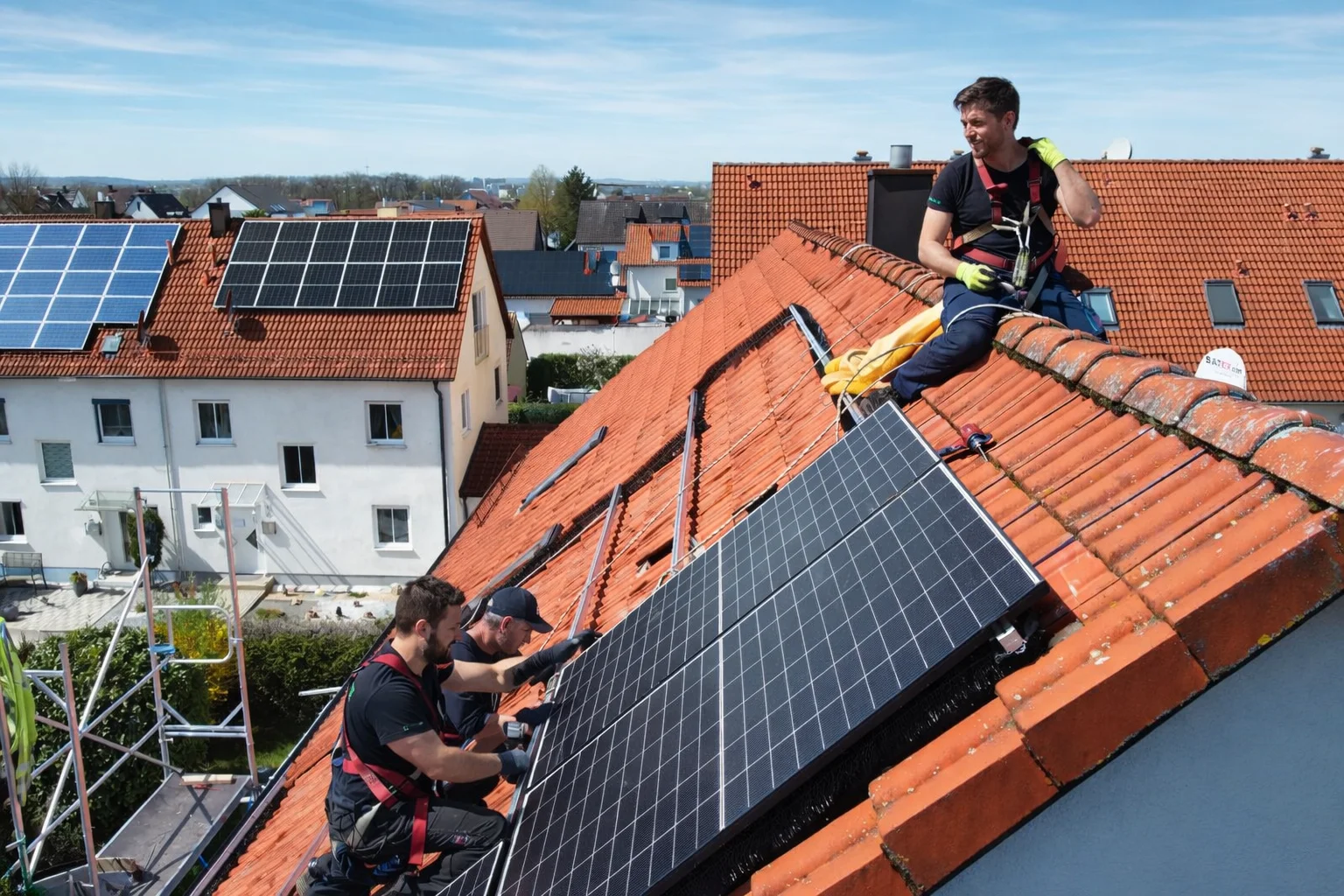 EMB-Monteure installieren PV-Module auf einem Wohnhausdach in Regensburg