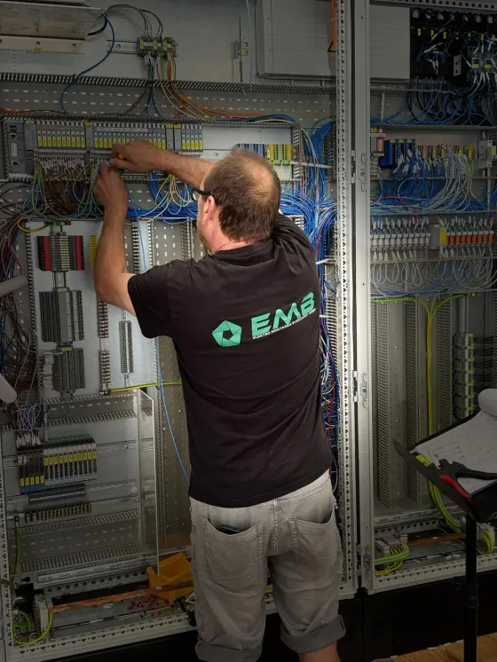 EMB-Mitarbeiter arbeitet an der Verdrahtung einer Schaltanlage in der Werkstatt in Neutraubling.